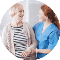 Friendly nurse and female senior patient looking at each other